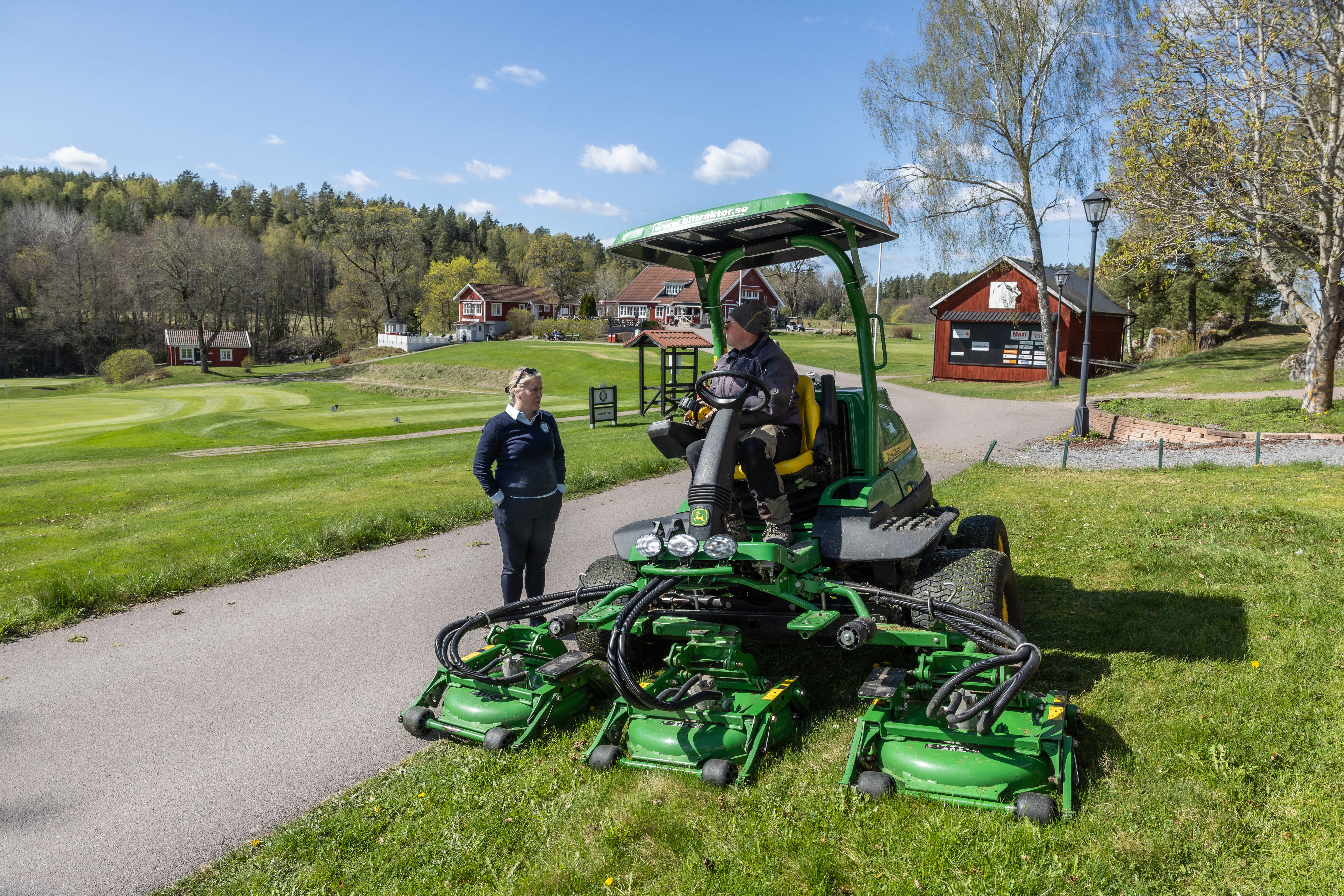 Bild på Lena Björkdahl, klubbchef för Köpings Golfklubb, och banmedarbetaren Clas Gimberger som kör en ruffklippare.