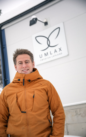 Bild på Emanuel Nygren, vd för Umlax, som står utanför företagsbyggnaden med skylt där det står "Umlax".