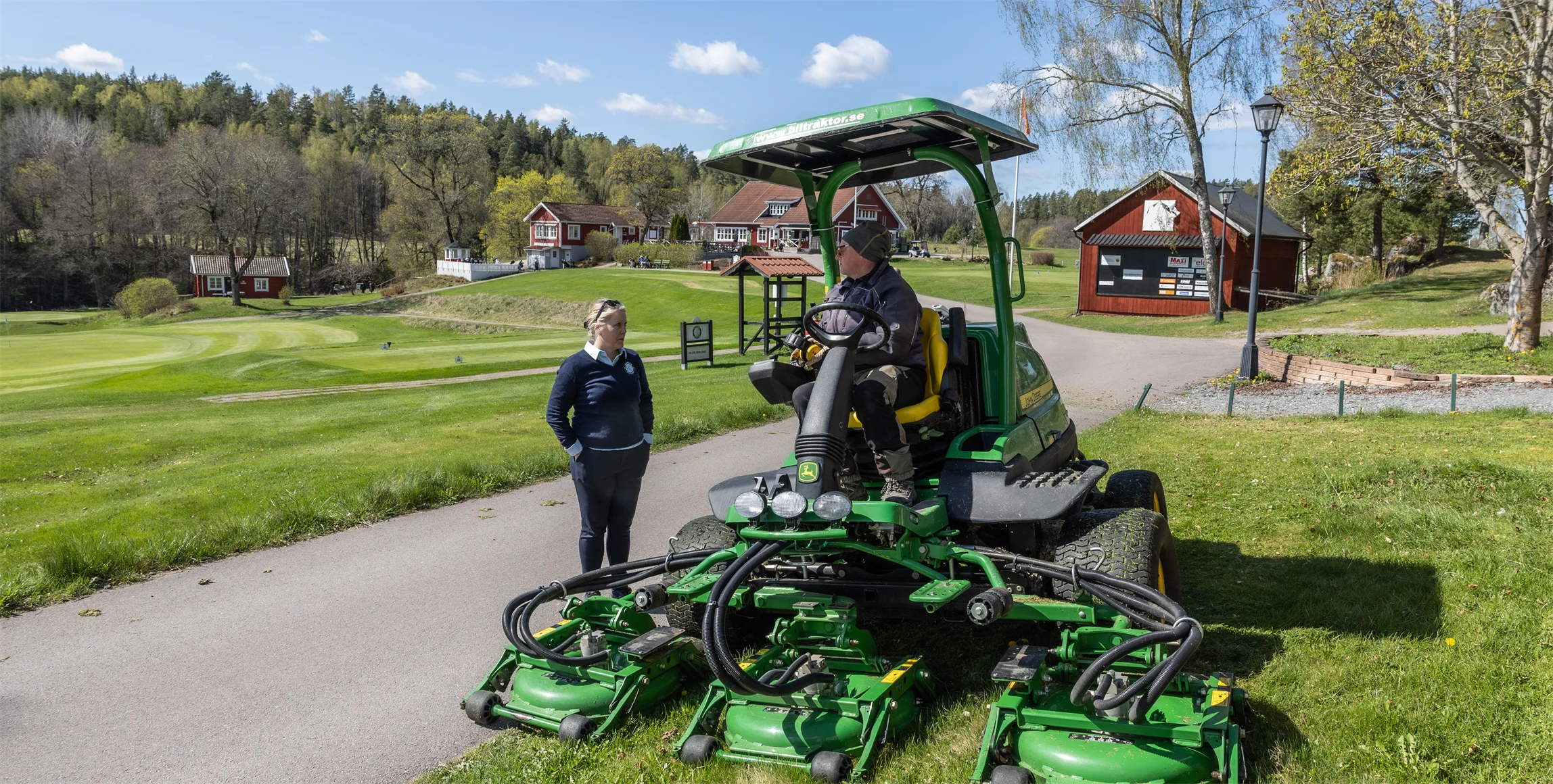 Bild på Lena Björkdahl, klubbchef för Köpings Golfklubb, och banmedarbetaren Clas Gimberger som kör en ruffklippare.