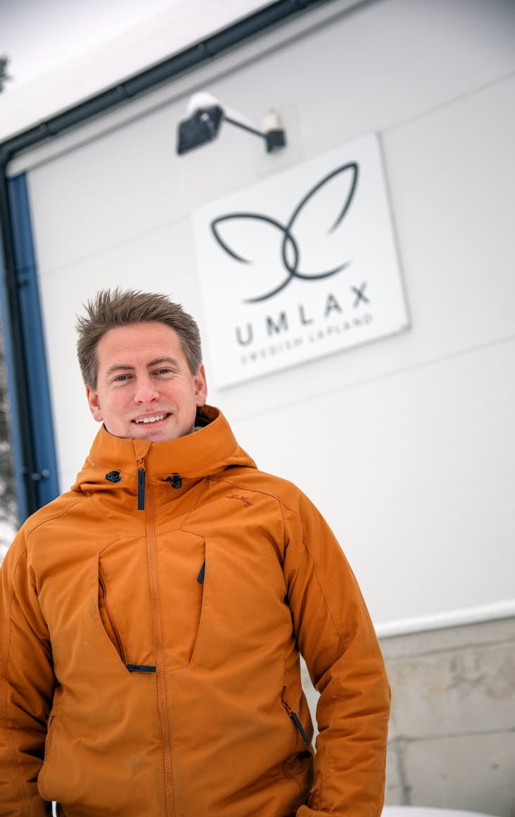 Bild på Emanuel Nygren, vd för Umlax, som står utanför företagsbyggnaden med skylt där det står "Umlax".