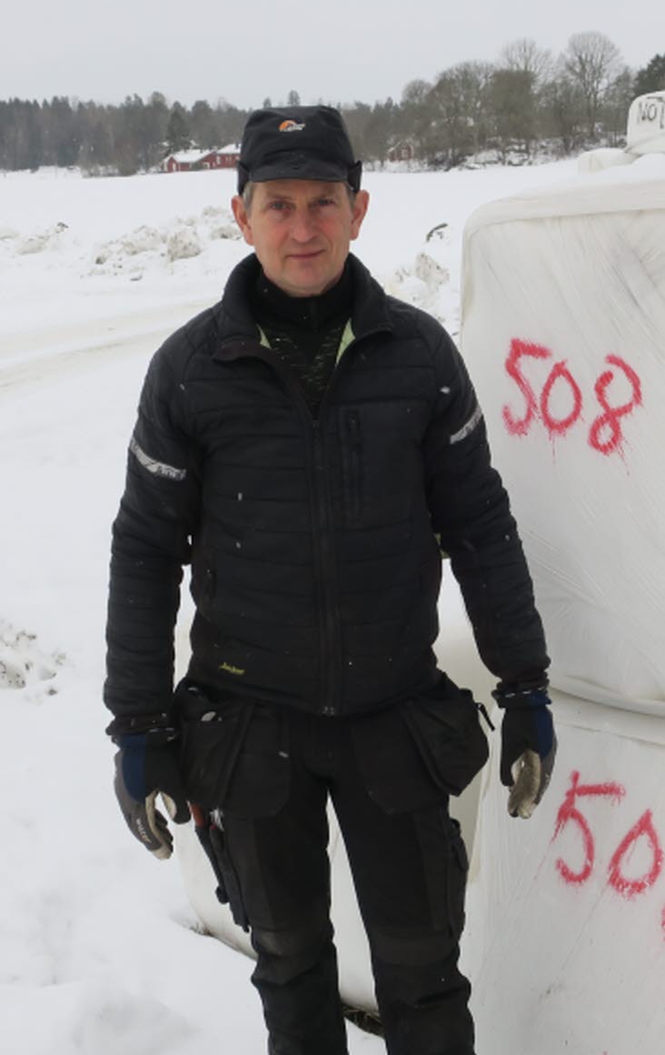 Bild på Nils Söderberg, Helleby Gård, framför balar.